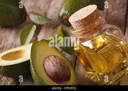 Avocado-Öl in einer Glasflasche mit einer Tabelle Großaufnahme. Horizontale Stockfoto