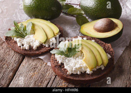 Frühstück Brötchen mit Frischkäse und Avocado close-up auf dem Tisch. horizontale Stockfoto