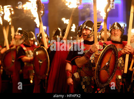 Die Eröffnungsveranstaltung der Hogmanay-Feierlichkeiten in Edinburgh beginnt mit der jährlichen Fackelprozession, Tausende von Fackelträgern, angeführt von Shetlands Up Helly AA' Vikings (im Bild), und die massierten Rohre und Trommeln marschieren durch das Stadtzentrum zu einem spektakulären Feuerwerk-Finale vor den Hogmanay-Feierlichkeiten zum neuen Jahr. Stockfoto