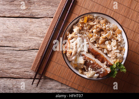 Katsudon - panierte Japanisch Tiefe gebratenes Schweinefleisch Kotelett Tonkatsu garniert mit Ei auf Reis. horizontale Ansicht von oben Stockfoto
