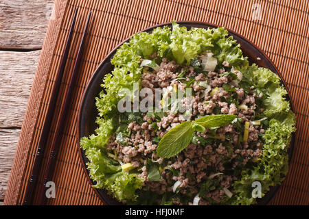 Asiatische Küche: Salat von Hackfleisch / Faschiertem mit Kräuter-close-up auf dem Tisch. horizontale Ansicht von oben Stockfoto