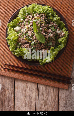 Asiatische Küche: Salat von Hackfleisch / Faschiertem mit Kräuter-close-up auf dem Tisch. vertikale Ansicht von oben Stockfoto