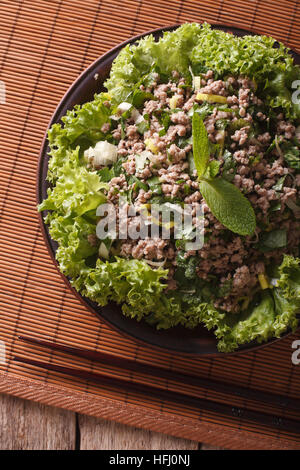 Asiatische Küche: Salat von Hackfleisch / Faschiertem mit Kräuter-close-up auf dem Tisch. vertikale Ansicht von oben Stockfoto