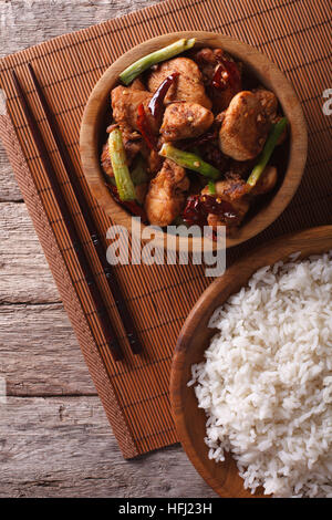 Kung Pao Chicken Filets in einer Schüssel hautnah und Reis. vertikale Ansicht von oben Stockfoto