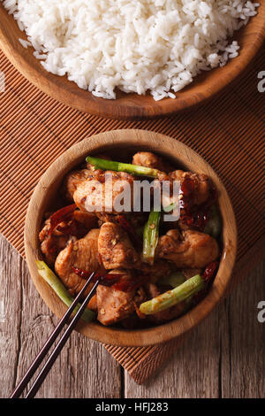Kung Pao Hühnerfleisch in einer Schüssel hautnah und Reis auf dem Tisch. vertikale Ansicht von oben Stockfoto