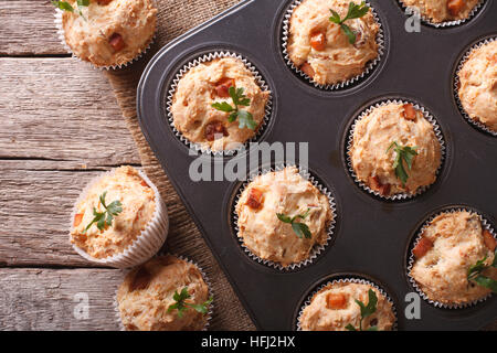 hausgemachte Muffins mit Schinken und Käse hautnah in Auflaufform legen. Horizontale Ansicht von oben Stockfoto