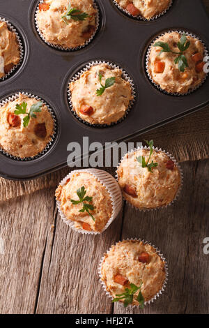 Muffins mit Schinken und Käse in Auflaufform hautnah auf dem Tisch. vertikale Ansicht von oben Stockfoto