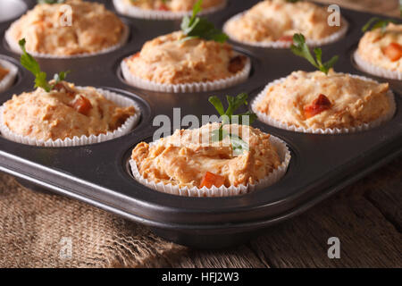 Vorspeise-Muffins mit Schinken und Käse in Auflaufform hautnah auf dem Tisch. horizontale Stockfoto