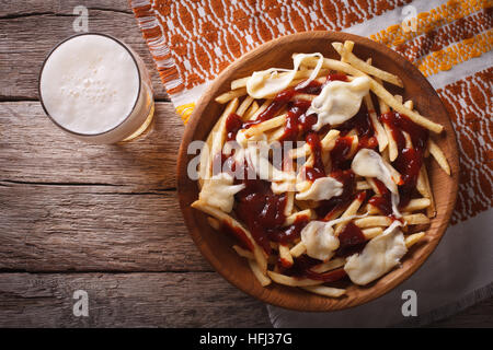 Poutine und Bier auf den Tisch-Nahaufnahme. horizontale Ansicht von oben Stockfoto