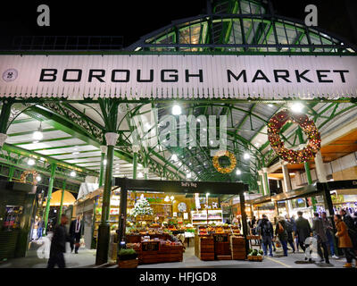 Die festliche Eingangsfassade des Borough Market wird nachts mit Weihnachtskränzen des Southwark London beleuchtet Stockfoto