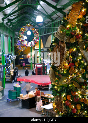 Erhöhte Sicht der späten Nacht Käse Marktstände und Verkostung Proben, Produkte unter dem Motto Weihnachten Kranz hängen im Vordergrund Borough Markt Southwark London SE1 Stockfoto