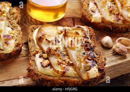 Frühstück knusprigen Toast Sandwich mit Birnen Blauschimmelkäse Pistazien und Honig Stockfoto
