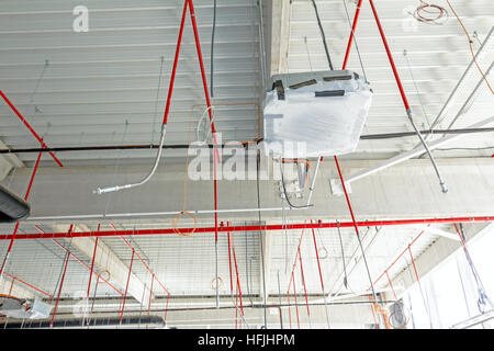 Lüftungsrohre in Silber Isolierung Material und Feuer Sprinkler auf rote Rohr hängen von der Decke in neue Gebäude. Stockfoto