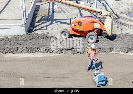 Über Ansicht auf Arbeiter arbeitet, die mit Vibrationsplatte, Müllpresse Maschine. Stockfoto