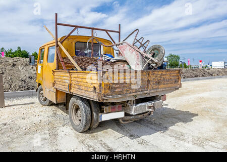 Kleine gelbe LKW geparkt ist, geladen mit verschiedenen Tools zur Baustelle, Stockfoto