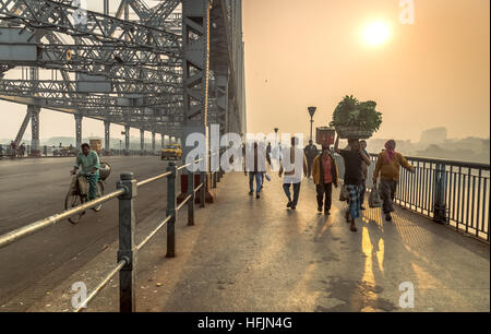 Anbieter und Pendler Howrah Brücke überqueren für ihre tägliche Arbeit am Fluss Hooghly an einem kalten, nebligen Wintermorgen Stockfoto