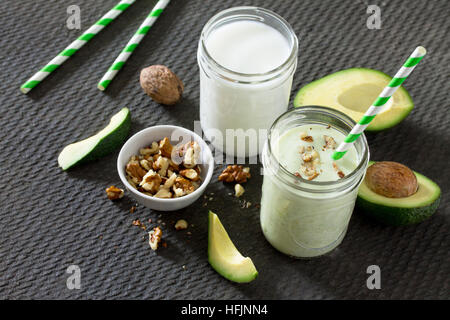 Gesundes Grün cocktail mit Avocado und Walnüsse in einer Bank des Glases auf dunklen Stein Hintergrund. Joghurt cocktail. Natürliche Entgiftung. Stockfoto