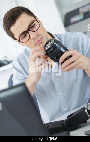Fotograf Löten wireless flash Trigger an seinem Arbeitsplatz Stockfoto
