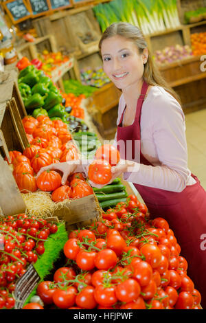 Shop Mitarbeiter tragen eine Kiste Tomaten Stockfoto