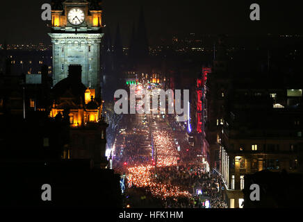 Die Eröffnungsveranstaltung von Edinburghs Hogmanay-Feiern beginnt mit der jährlichen Fackelprozession, während tausende Fackelträger, angeführt von Shetlands Up Helly AA' Vikings, und die massierten Pfeifen und Trommeln durch das Stadtzentrum zu einem spektakulären Feuerwerk-Finale vor den Hogmanay-Feiern zum neuen Jahr marschieren. Stockfoto