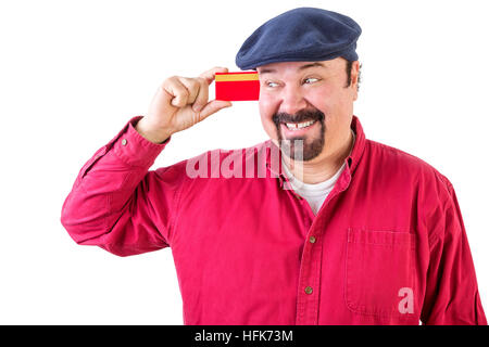 Fröhlichen Mann betrachtete seine Kreditkarte mit einem strahlenden Lächeln der Vorfreude, wie er all die Dinge vorstellt, die er kann gehen und kaufen, Oberkörper in ein rotes Hemd Stockfoto