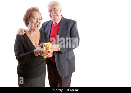 Überglücklich senior Frau empfangen Valentines Geschenk von ihrem liebevollen Ehemann, stilvolles Paar stehende Arm in Arm auf weiß mit Textfreiraum Stockfoto