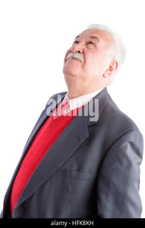 Nahaufnahme von Senior in Business-Anzug und roter Pullover sieht nach oben gegen einen weißen Hintergrund Stockfoto
