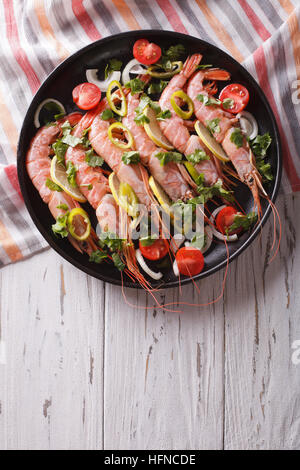 Garnelen mit Chili, Kräutern und Gemüse in einer Pfanne. vertikale Ansicht von oben Stockfoto