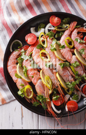 Garnelen mit Chili, Kräutern und Gemüse Nahaufnahme in einer Pfanne. vertikale Ansicht von oben Stockfoto