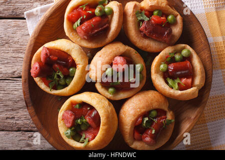 Yorkshire Pudding gefüllt mit Wurst und Gemüse auf einem Teller mit einer Tabelle Großaufnahme. horizontale Ansicht von oben Stockfoto