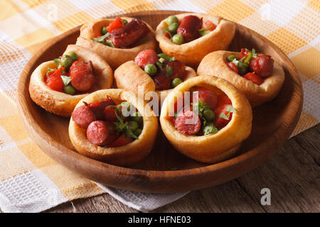 Yorkshire Pudding gefüllt mit Wurst und grüne Erbsen auf einem Teller auf den Tisch. horizontale Stockfoto