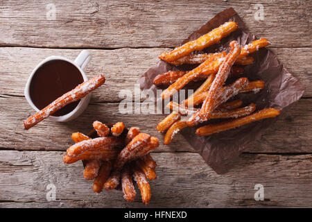 Churros und Schokolade auf dem Tisch. horizontale Ansicht von oben Stockfoto