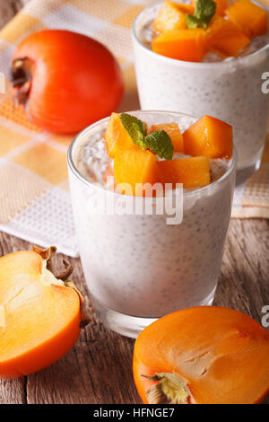 Gesundes Frühstück: Chia Samen Pudding und Persimmon close-up auf dem Tisch. vertikale Stockfoto