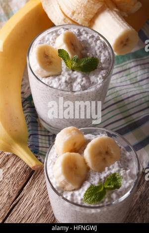 Gesundes Frühstück: Joghurt mit Chiasamen und Banane in ein Glas Nahaufnahme. Vertikal Stockfoto