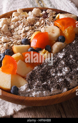 Gesundes Frühstück: Haferflocken mit Obst und Chia Samen Nahaufnahme auf einer Platte. Vertikal Stockfoto