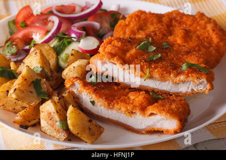 Geschnittenes Schweinefleisch Schnitzel, Salat und Bratkartoffeln auf eine Platte Nahaufnahme. horizontale Stockfoto