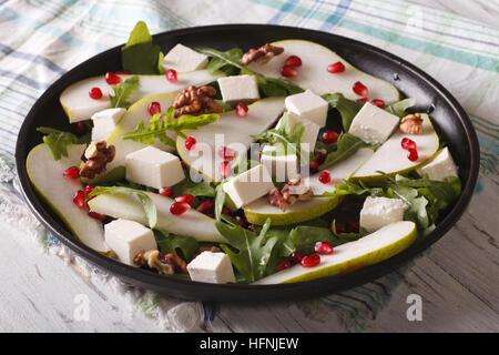 Gesunder Salat mit Birnen, Granatäpfel, Feta und Rucola Nahaufnahme auf einer Platte. horizontale Stockfoto