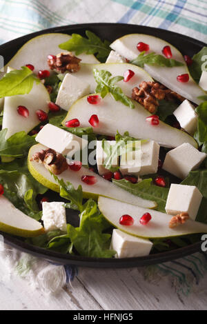 Frischer Salat mit Birnen, Granatäpfel, Käse, Walnüssen und grünen hautnah auf einem Teller. vertikale Stockfoto