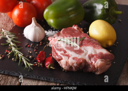 rohes Schweinefleisch Hals und Gemüse Nahaufnahme auf Schneidebrett. horizontale Stockfoto