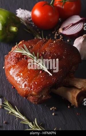 Gebackenes Schweinefleisch Schaft und Zutaten Nahaufnahme auf einer Schiefertafel Tafel. vertikale Stockfoto