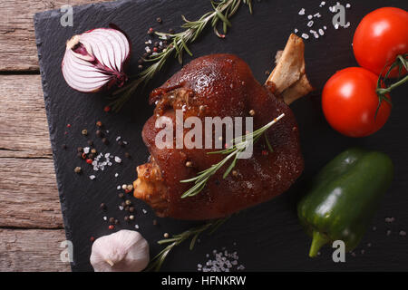 Gebackenes Schweinefleisch Schaft und frischem Gemüse hautnah auf einer Schiefertafel Tafel auf den Tisch. horizontale Ansicht von oben Stockfoto