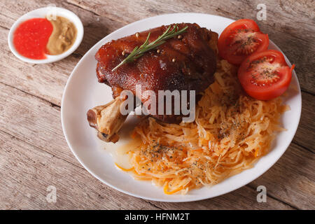 Böhmische Küche: gebackenes Schweinefleisch Schaft und Sauerkraut Closeup auf einem Teller. horizontale Stockfoto