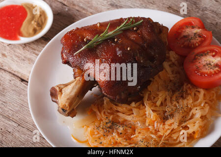 Europäische Küche: gebackenes Schweinefleisch Eisbein und Sauerkraut Closeup auf einem Teller. horizontale Stockfoto