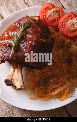 gebackenes Schweinefleisch Eisbein und Sauerkraut Nahaufnahme auf einer Platte. vertikale Stockfoto