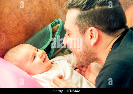 Papa macht Gesichter Grimassieren neugeborenes Baby lacht Stockfoto