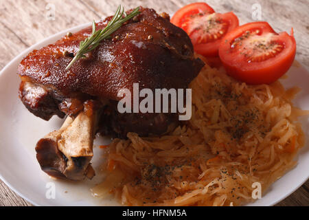 Lecker gebackene Schweinefleisch Schaft und Sauerkraut Nahaufnahme auf einer Platte. horizontale Stockfoto