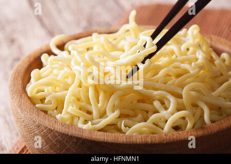 Asiatisches Essen: Ramen Nudeln Makro in eine hölzerne Schüssel auf dem Tisch. Horizontale Stockfoto