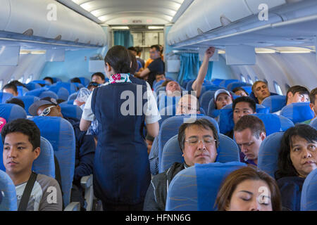 Flugbegleiter und Passagiere auf Philippine Airlines Flug von Manila Stockfoto