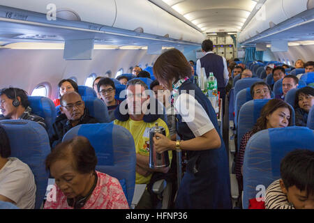 Flugbegleiter und Passagiere auf Philippine Airlines Flug von Manila Stockfoto