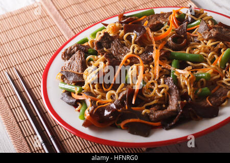 Chinesische Nudeln mit Rindfleisch, Mauser und Gemüse Nahaufnahme auf einer Platte. horizontale Stockfoto